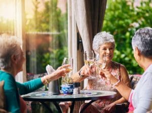 seniors clinking their wine glasses together over brunch