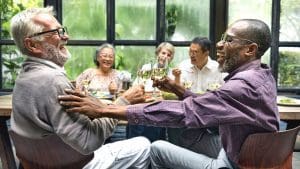 seniors smiling and clinking their wine glasses together over dinner