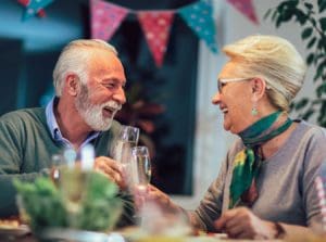 senior couple smiling and clinking their wine glasses together