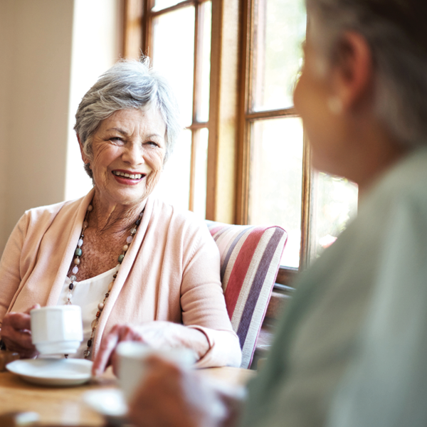 senior women laughing together while enjoying coffee