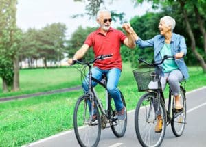 senior couple enjoying a bike ride through a park together