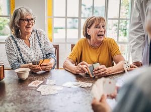 Senior women playing cards and having fun in a senior living community