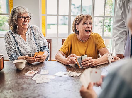 Senior women playing cards and having fun in a senior living community