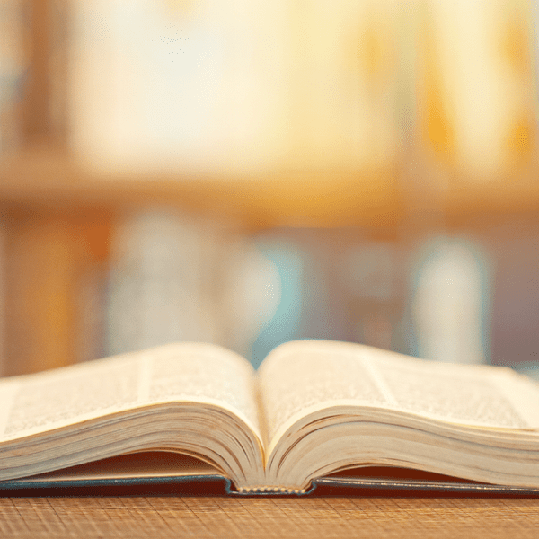hardback book laying open on a wood table