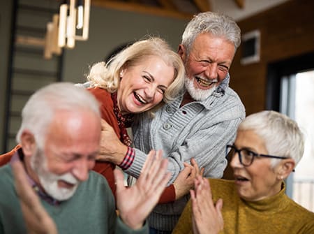Cheerful mature couples laughing at home
