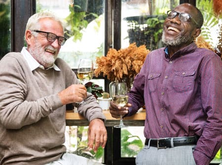senior men laughing and enjoying white wine