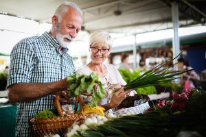 Senior couple shopping vegetables and fruits on the market