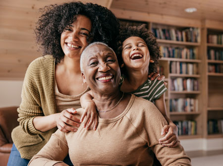 3 generations of an ethnic family smiling and laughing