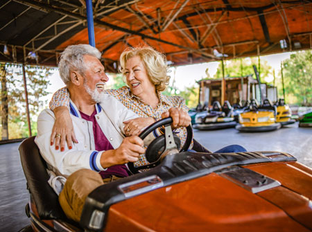 senior couple riding bumper cars together