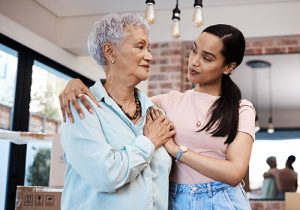 Adult daughter with arm around her senior mother