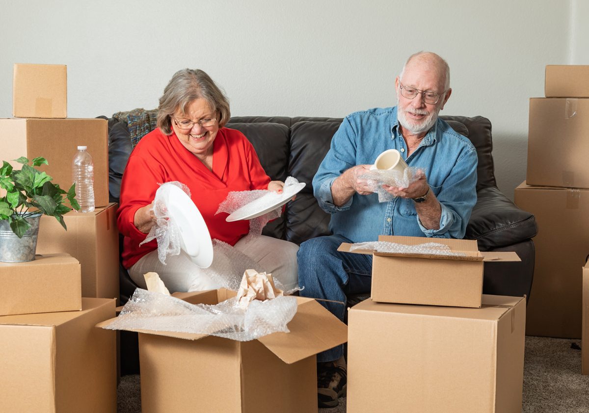 Senior Adult Couple Packing or Unpacking Moving Boxes