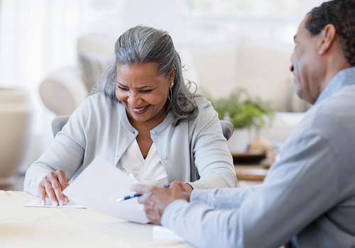 Senior husband and wife sitting at the breakfast table reviewing their finances together