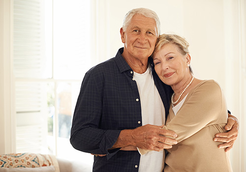 happy senior couple in a loving embrace at home