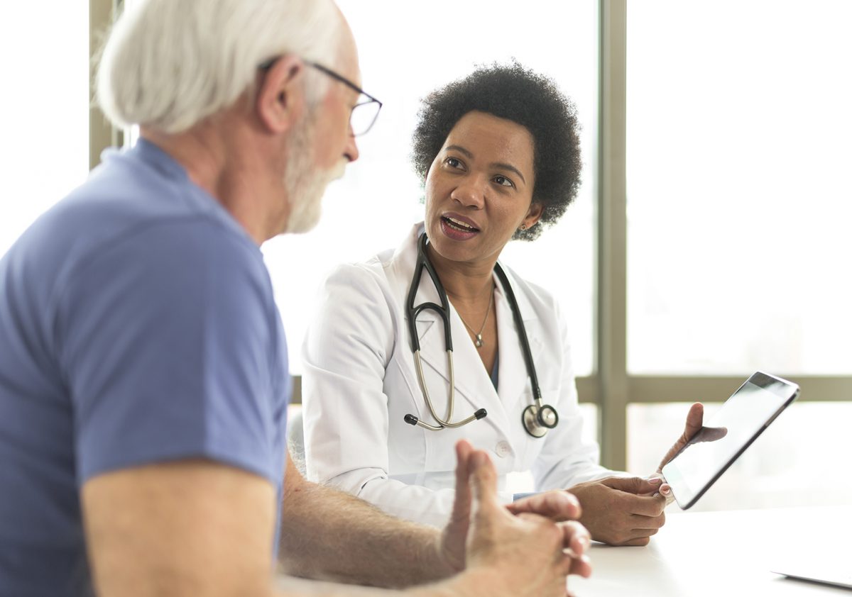 Serious retired man consulting with doctor