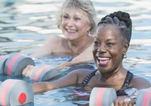 Senior woman and friend doing water aerobics