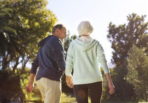 Senior couple holding hands and walking in park