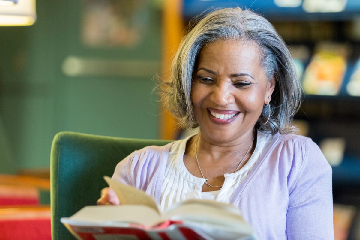 Senior woman enjoys reading in the library