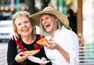 Senior Women Eating Street Food and Laughing