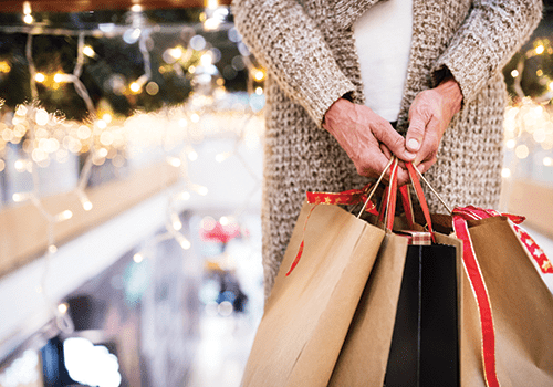 senior woman holding holiday shopping bags