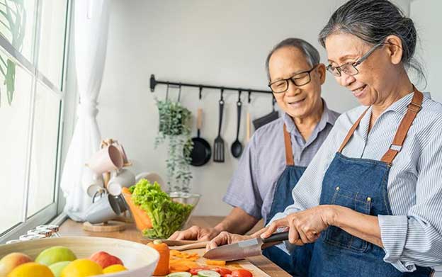 senior couple chopping vegetables in their kitchen
