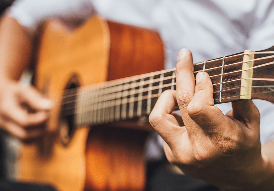 close up of a person playing an acoustic guitar