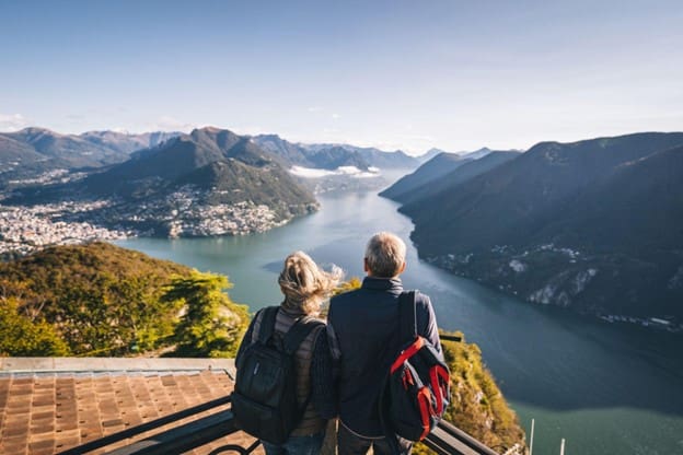 traveling senior couple looking at a mountain landscape