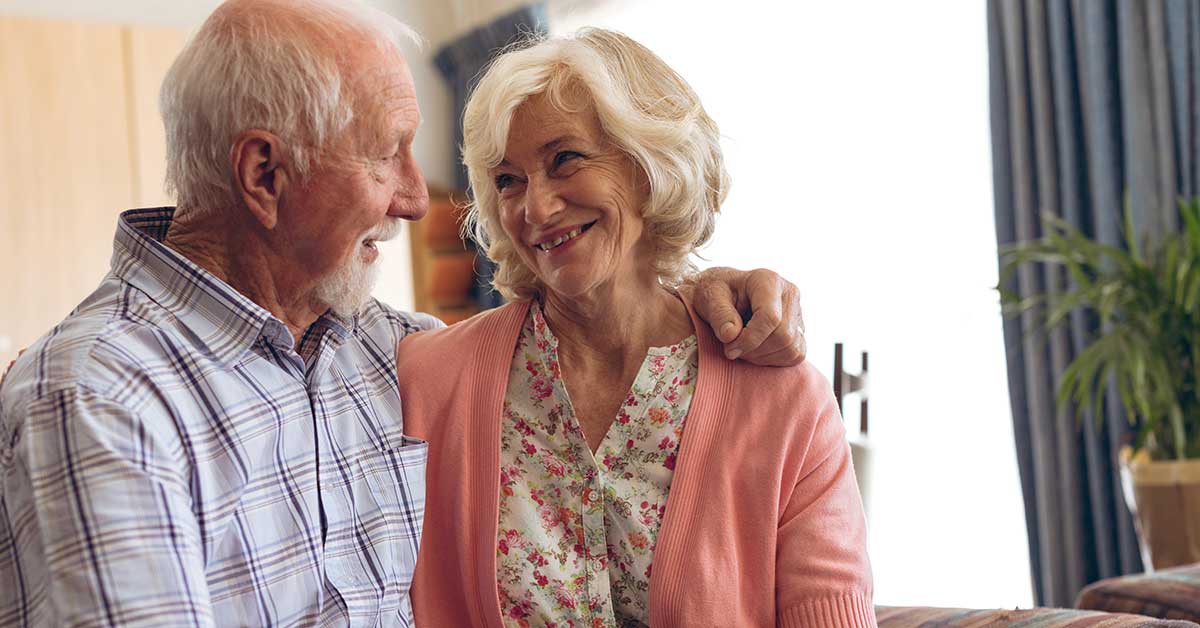 Senior couple sitting on sofa at home